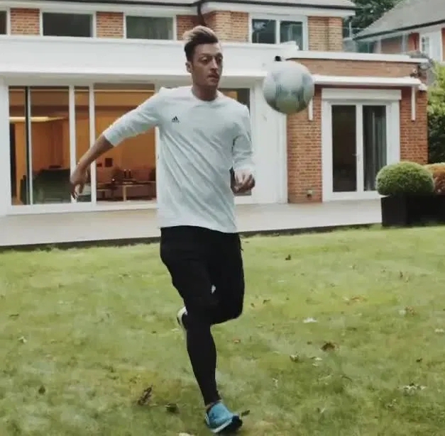 Mesut Ozil playing football at the front of his mansion
