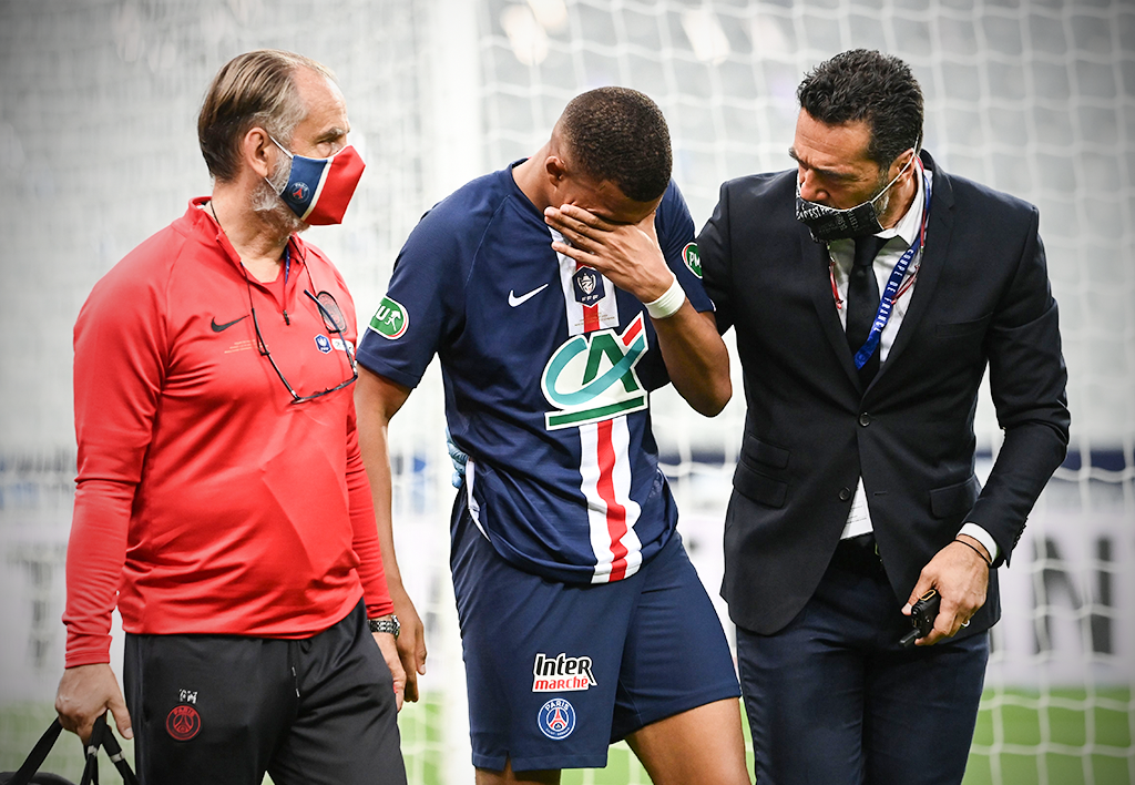 Kylian Mbappe helped out of the pitch after the tackle 
