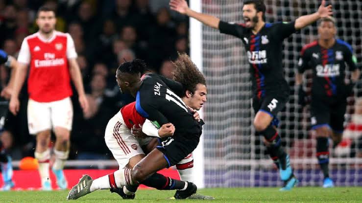 Matteo Guendozi giving Crystal Palace's Wilfried Zaha his best tackle 