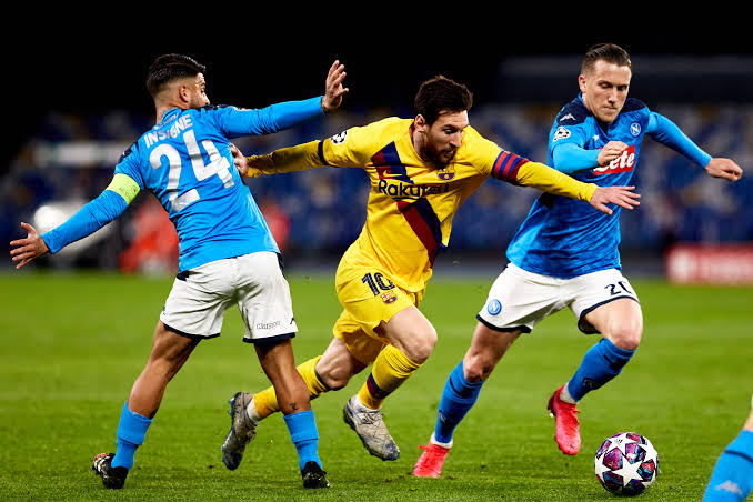 Barcelona talisman Lionel Messi forcing himself through Napoli's players during the first leg of the UEFA Champions League round of 16 match in Naples, Italy.