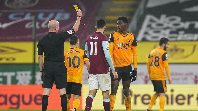 Referee Lee Mason showing Wolves' Owen Otasowie a yellow card during the match.