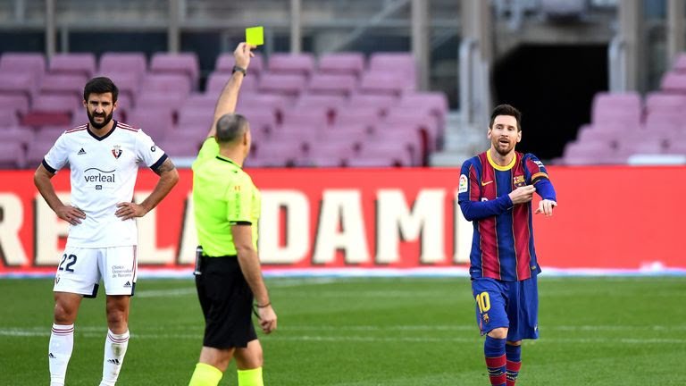 Lionel Messi being shown a yellow card after removing his Barcelona jersey to pay tribute to late Diego Maradona on Sunday. 