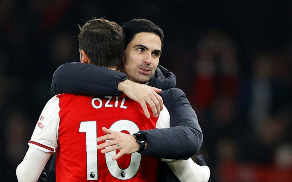 Mesut Ozil hugs Arsenal's coach Mikel Arteta.