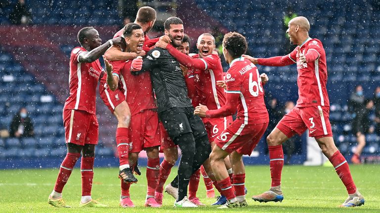 Liverpool players celebrate with Alisson after scoring a historic goal against West Brom.