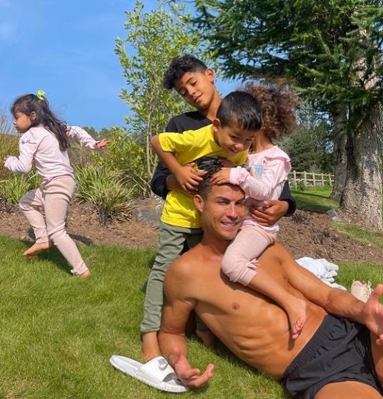 Cristiano Ronaldo and his four kids relaxing on the field of the £6 million mansion. 