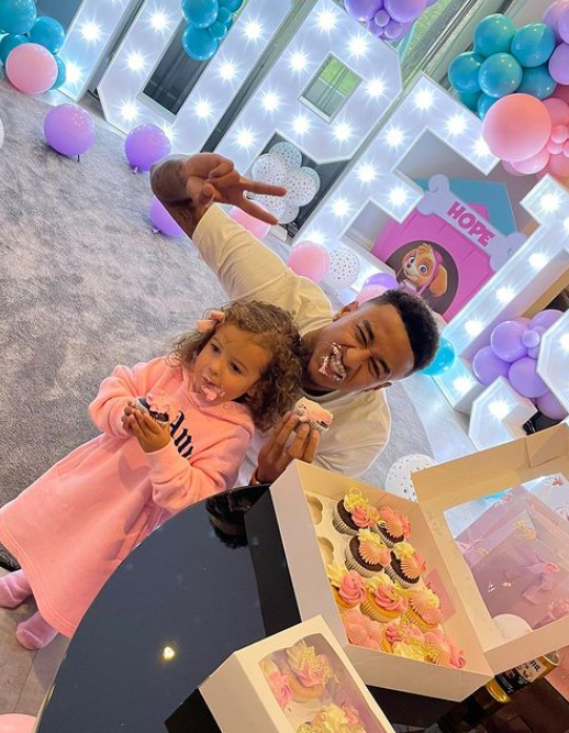 Lingard posing with Hope with cake particles on their lips.