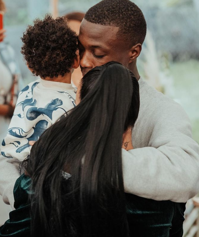 Nicolas Pepe embracing his wife while carrying his son. 