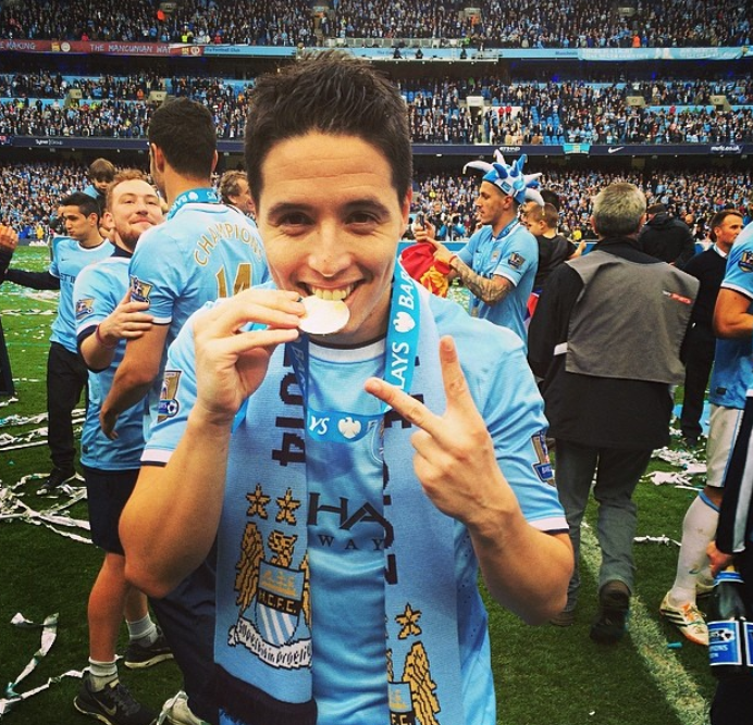 Samir Nasri celebrates with his medal after helping Manchester City to win the 2013–2014 Premier League title.  