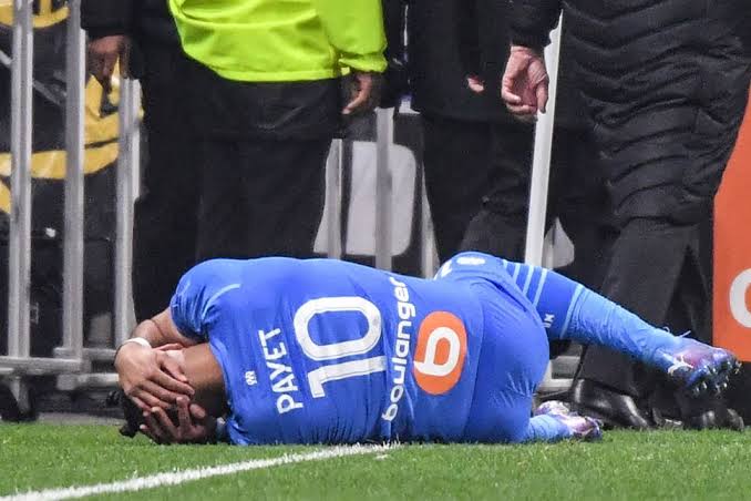 Dimitri Payet lands on the ground after he was hit with a plastic bottle. 