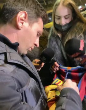 Lionel Messi signing a fan's shirt during his visit to FC Barcelona this week. 