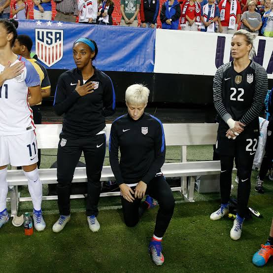 Megan Rapinoe taking a knee while the national anthem is being sung. 