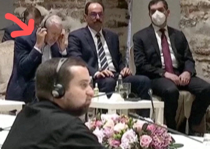 Roman Abramovich trying to listen to the speech of Turkey's president Recep Tayyip Erdoğan via headphones. 