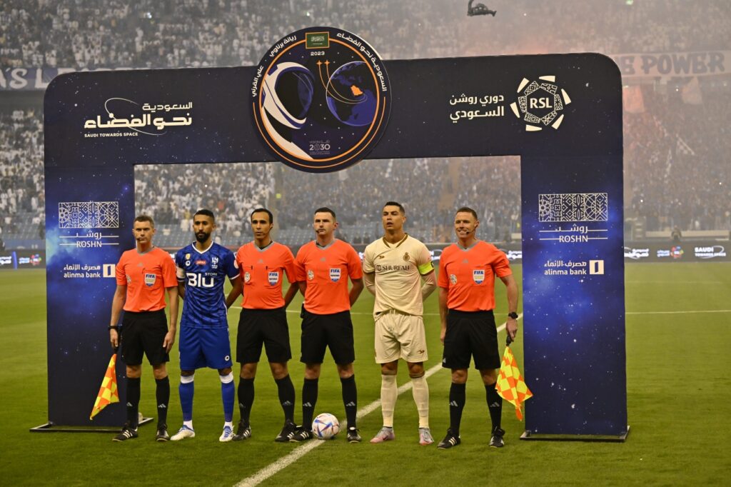Michael Oliver alongside his refereeing team, Cristiano Ronaldo and Al Hilal's captain 